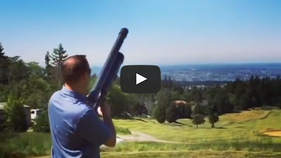 Man standing with golf ball launcher ready to fire